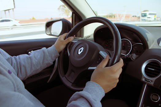 Close-up of hands on steering wheel while driving through Mexico in daylight.