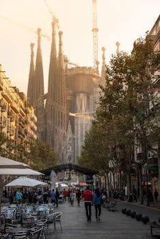 Morning street scene with Sagrada Familia in Barcelona. Iconic landmark and bustling atmosphere.