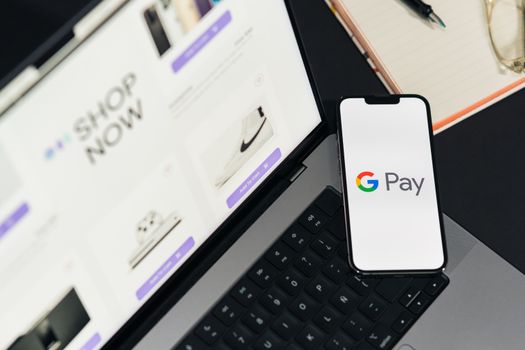 Smartphone with Google Pay on laptop for online shopping convenience.